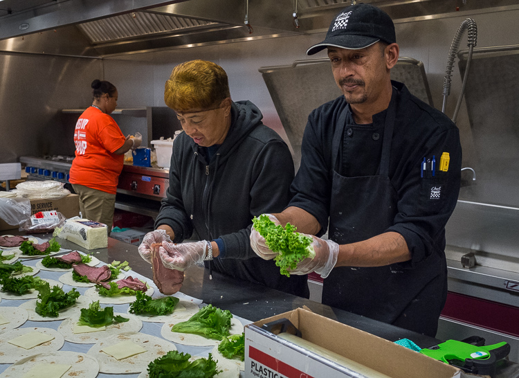 Vivian Kelly-Seabron (left) and Nick Curell make roast beef wraps in the production kitchen at the Food Bank of Eastern Michigan in Flint.