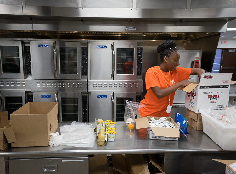 Monique Mosley prepares snack bags in the production kitchen at the Food Bank of Eastern Michigan in Flint.