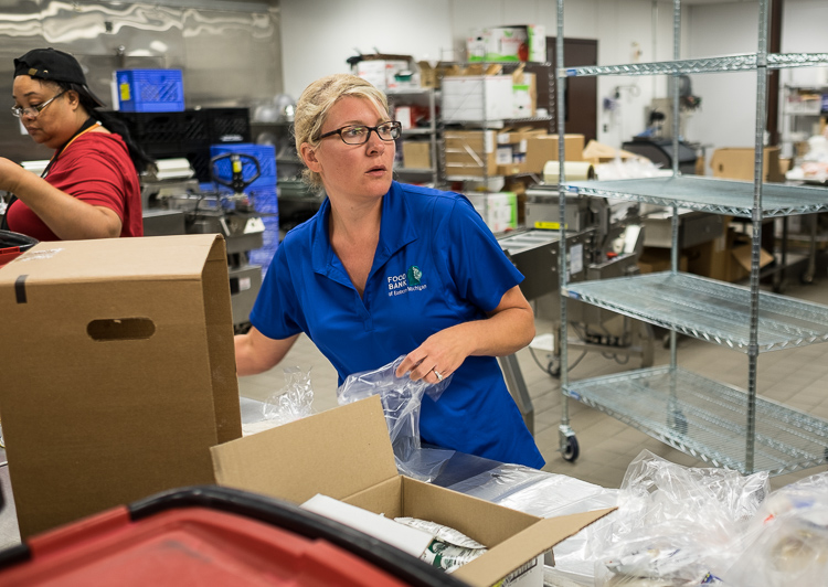 Shannon Mallory, director of culinary services at the Food Bank of Eastern Michigan, spends some of her time packaging meals in the production kitchen at the Food Bank of Eastern Michigan in Flint.