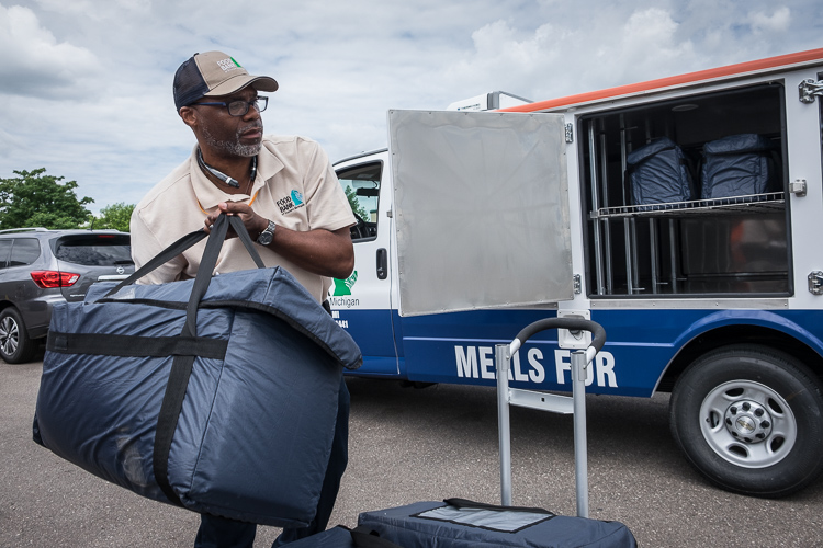 Samuel Berry Sr. loads his truck at the Food Bank of Eastern Michigan in Flint before beginning his run to seven mobile sites in Flint, Mt. Morris Township and Davison.  The bags contain individually packaged meals.