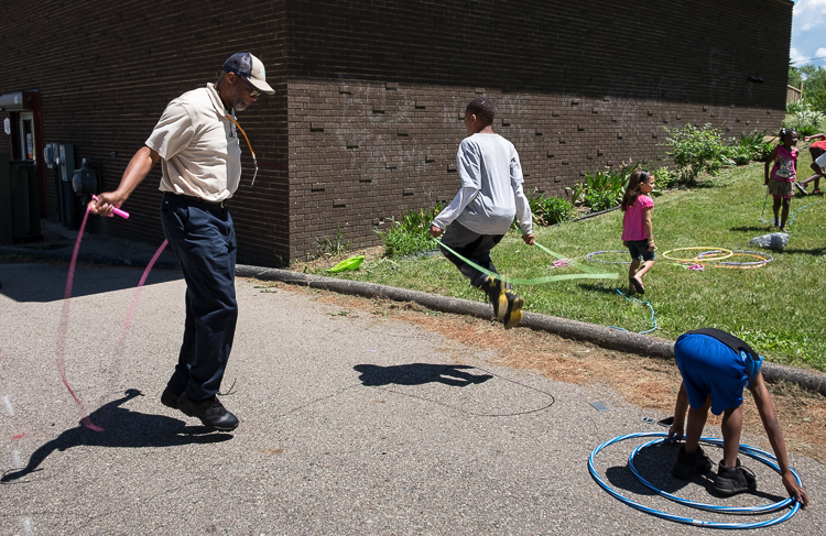 Samuel Berry Sr. takes a few minutes to jump rope with children in a summer program at the Beecher-Vera B. Rison Library in Mt. Morris Township. Part of Berry's job is to engage with the children at the sites. It is one of seven stops per day for Ber