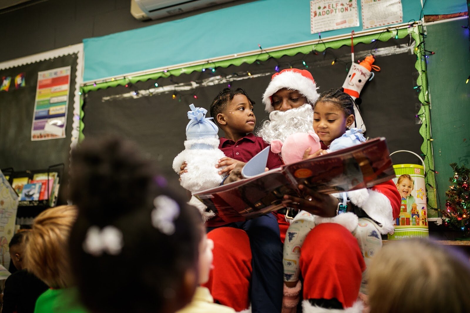 Genesee County Sheriff Deputy Blanding reads The Polar Express to kindergarteners during Freeman Elementary’s holiday celebration of literacy and reading comprehension on Friday, Dec. 16, 2022. (Jenifer Veloso | Flintside)