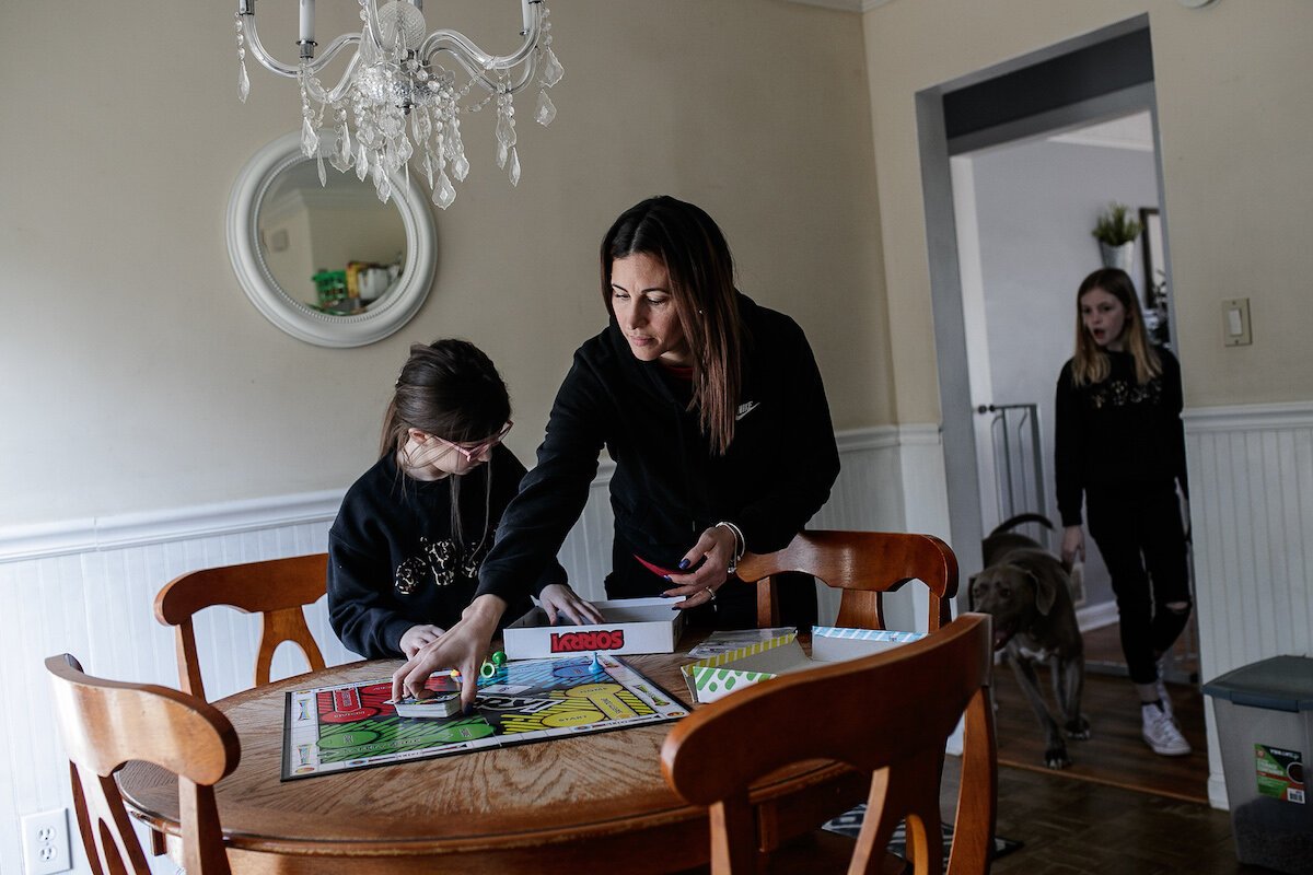 Giselle, Yuliette and Lily Parks set up a board game to play together at home.