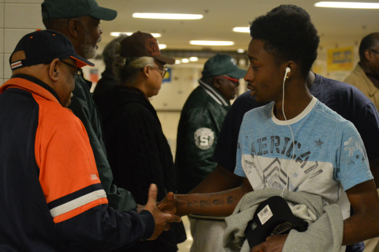 About 30 volunteers regularly welcome students at Flint Northwestern High School. 