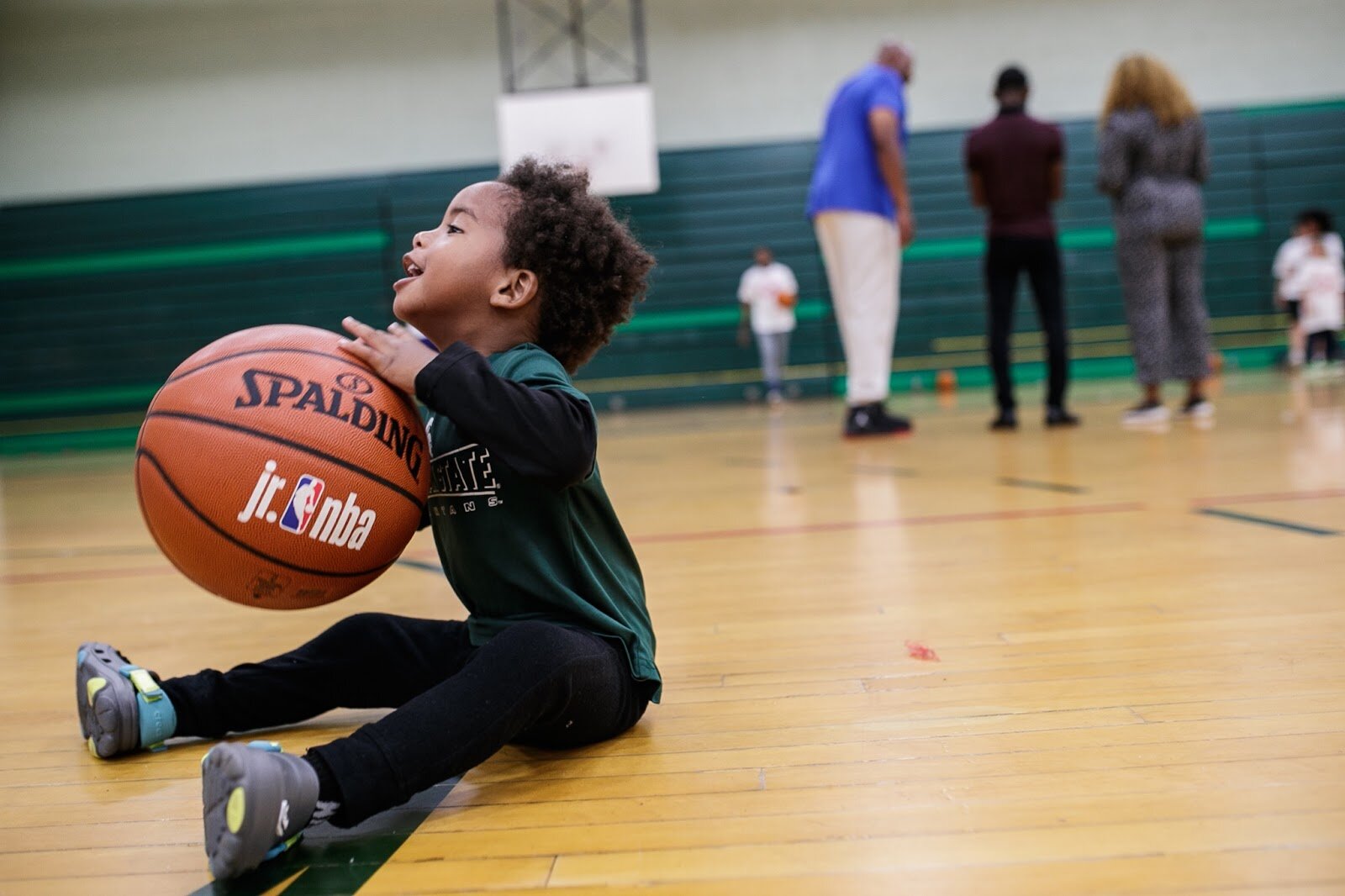 Jaxx Jones plays with a basketball during the 'Hami Day' basketball camp at Flint Northwestern High School.