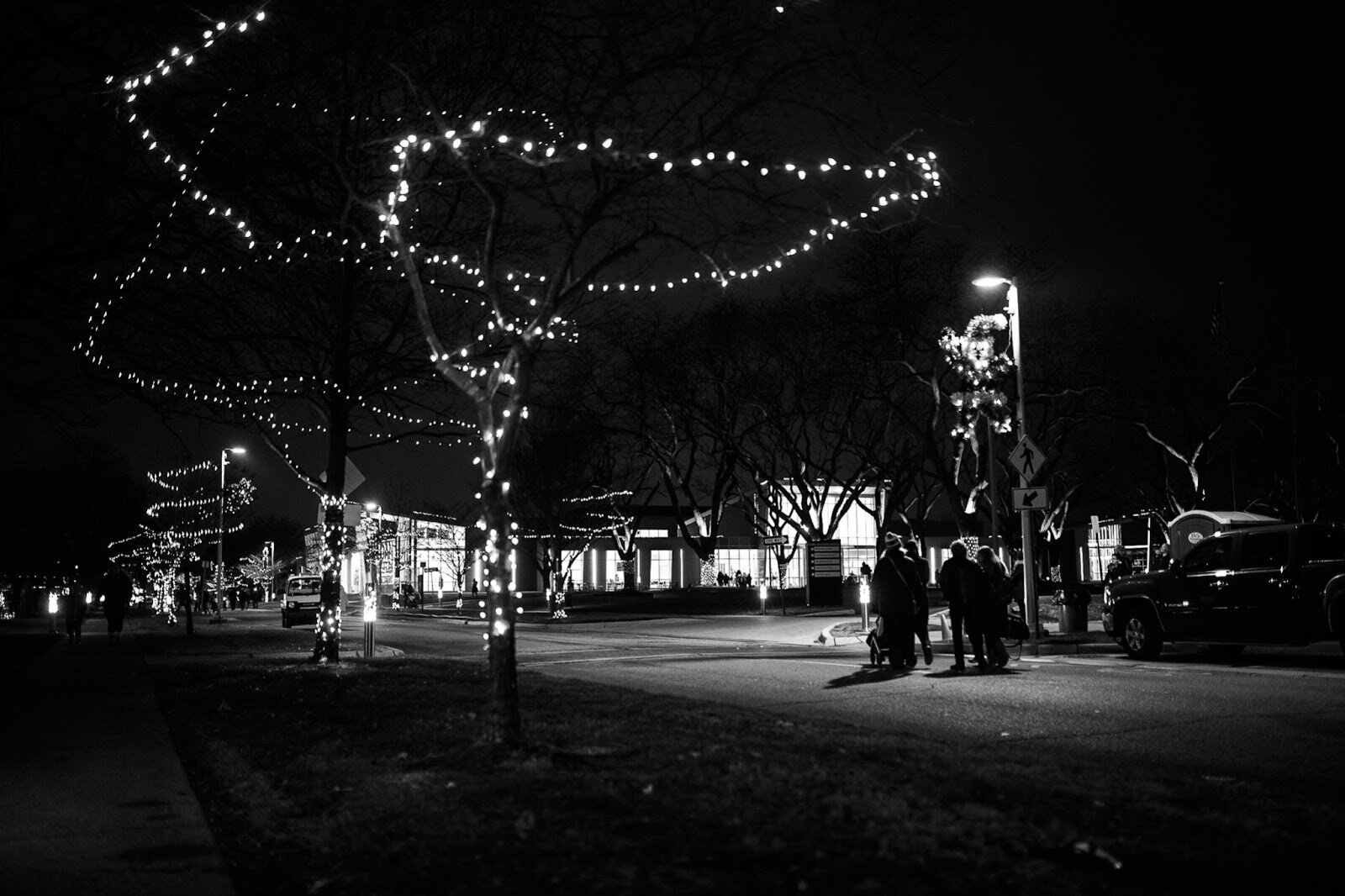 Holiday Walk guests walk together down Kearsley Street during the College Cultural area’s 37th Annual Holiday Walk in Flint on Tuesday, Dec. 6, 2022.