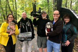 Katie Bach (left) and her husband, Matt, (second from right) pose with the film crew from 'House Hunters' and their two dogs Chewie and Chester.
