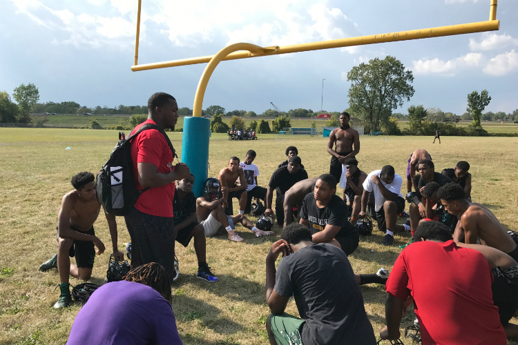 Football coach Chris Wilson talks to his players about their upcoming first game as the Jaguars.