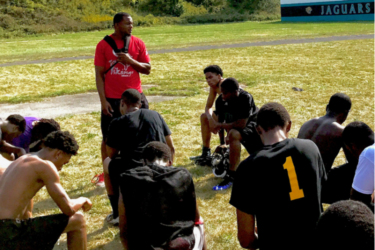 Football coach Chris Wilson talks to his players about their upcoming first game as the Jaguars.