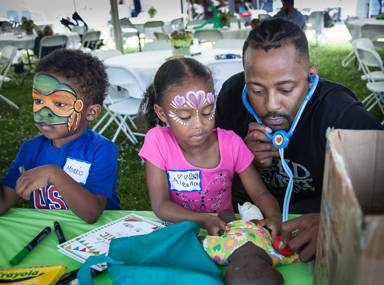 Former MSU basketball standout and Flintstone Morris Peterson plays with his son Morris III (left) and daughter Aleena at the 8th Annual Miracle Picnic at the Sloan Museum on Tuesday.  