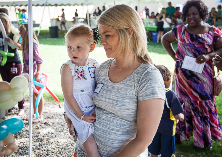 Hadlee Deines, 3, and mother Danielle Deines wait to have Hadlee's face painted at the 8th Annual Miracle Picnic at the Sloan Museum on Tuesday. 