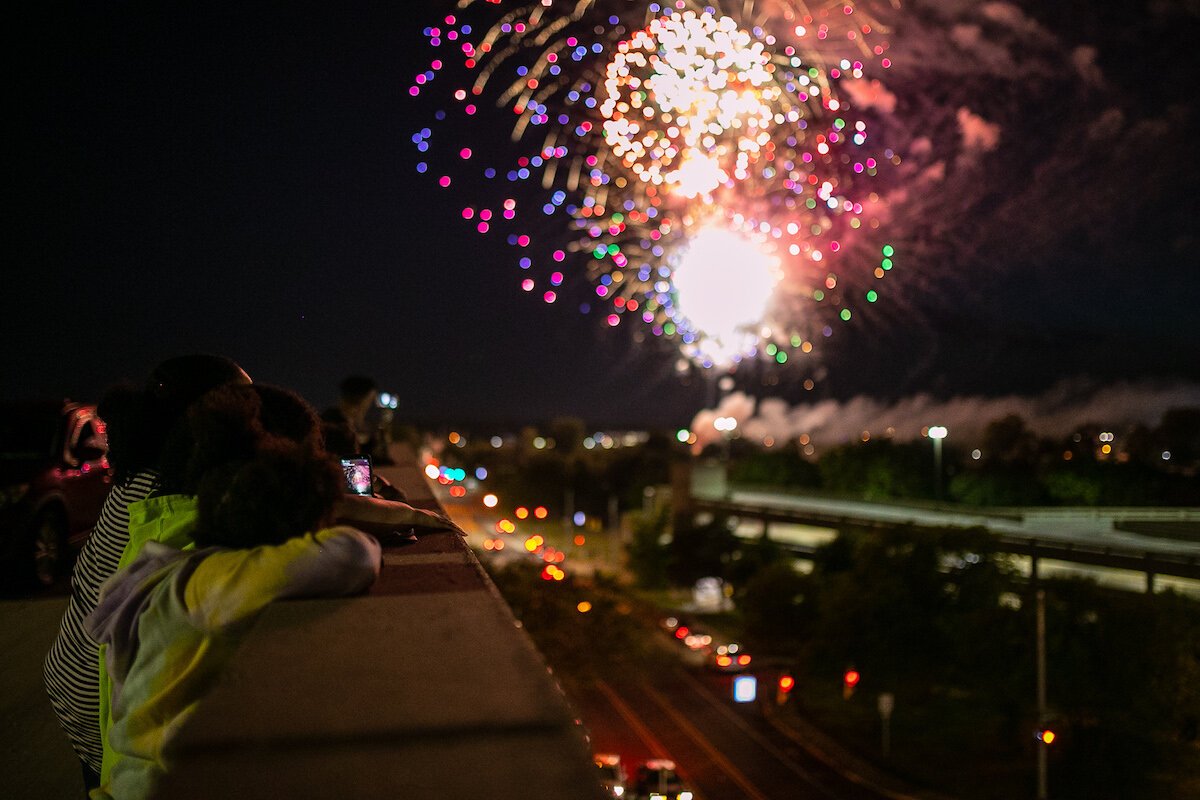 Spectators watch fireworks over the Flint River on Juneteenth.