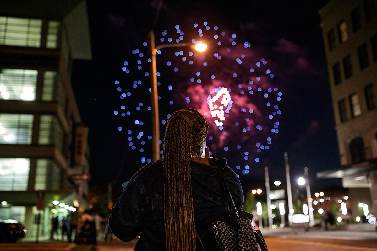 A spectator watches fireworks from downtown Flint during Juneteenth.
