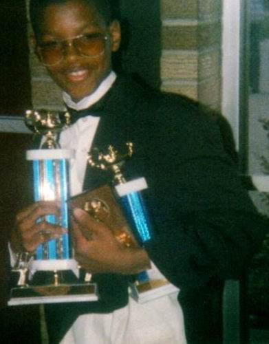 Isaiah excelled in school. Here he is with his spelling bee, all A's, and principal's award trophies at his sixth grade graduation from Brownell Elementary.