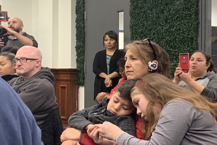 A resident listens to a live audio translation of a presentation of the Water Box at a community town hall at the Latinx Community and Technology Center on Monday, Nov. 25.