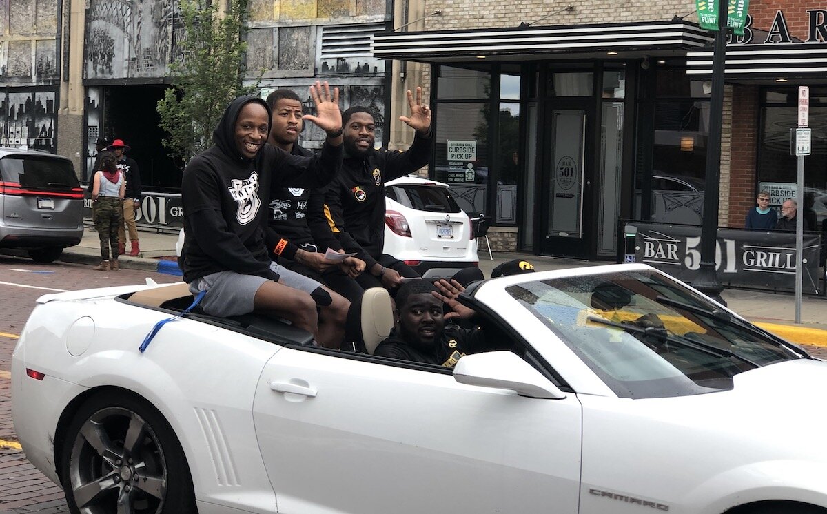 Members of the Flint United basketball team wave to the crowd during Flint's Juneteenth parade.
