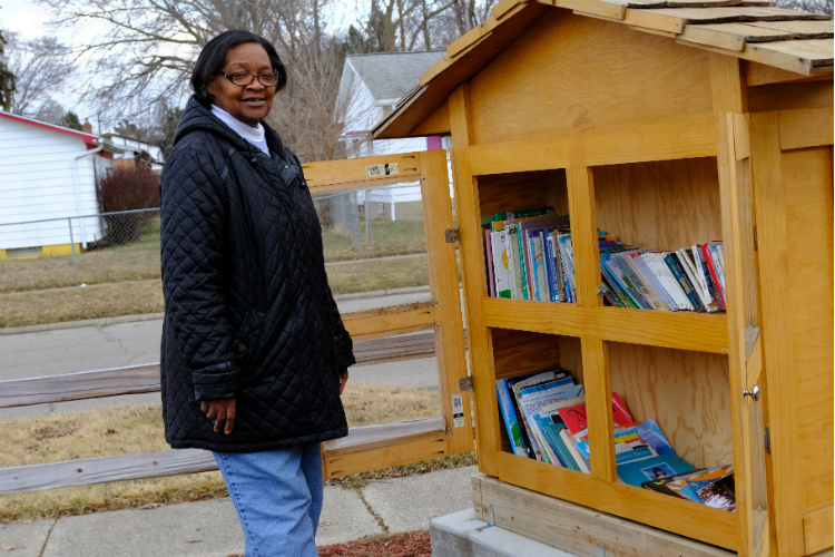 Jeanette Edwards, founder and president of the Brownell-Holmes Neighborhood Association, stands near the little library the block club built two years ago.