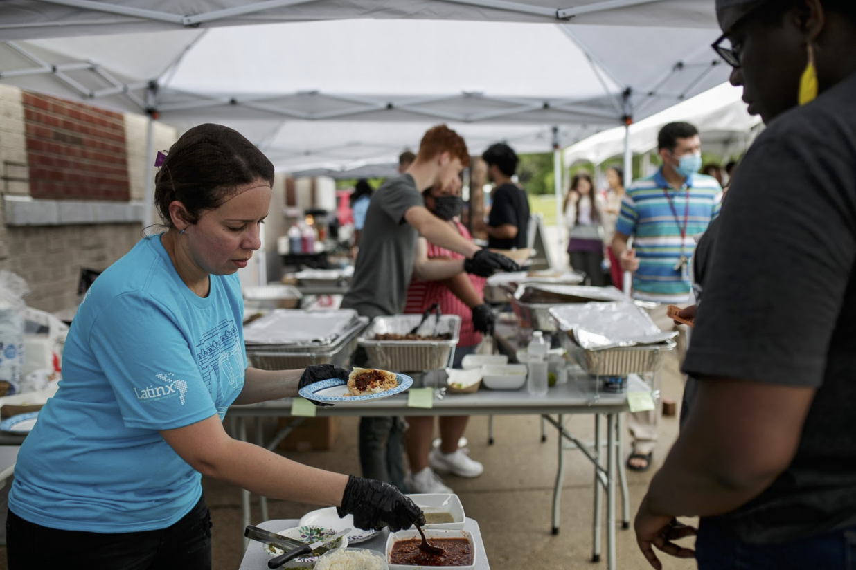 A volunteer serves an arepa at the Latinx Technology Center's 20th year anniversary.