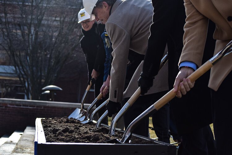 Flint community leaders dig into the ceremonial plot of dirt to the usher in the construction of Kettering University's Learning Commons.