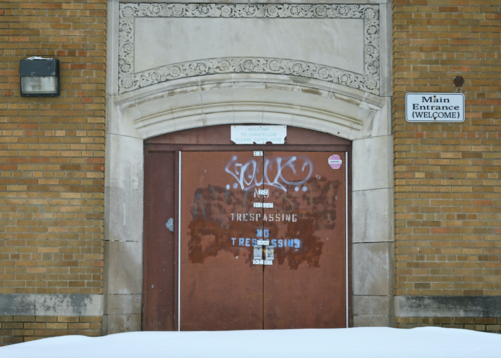 The main entrance of Longfellow Middle School in Flint, Michigan displays "no trespassing" warnings and graffiti on March 13, 2023. The school closed its doors in 2007.