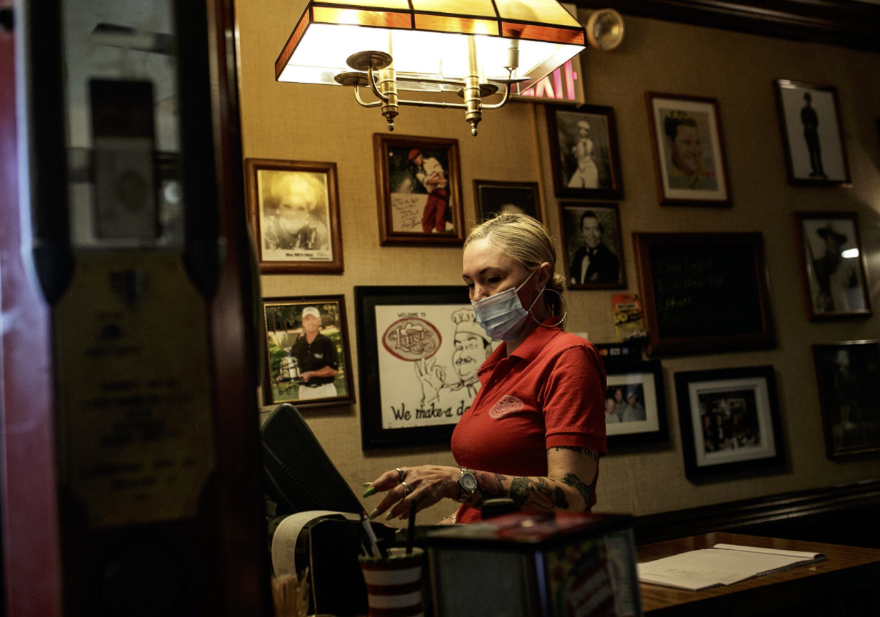 Danielle Groce checks out a returning customer picking up takeout pizza.