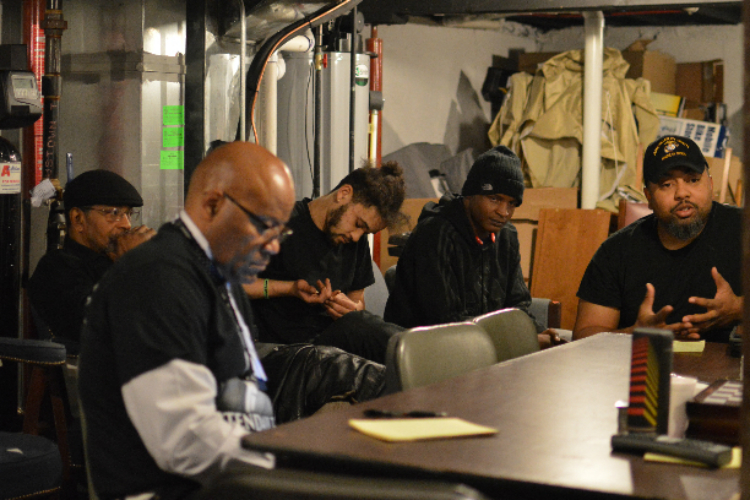 A group of eight to 10 young men and their mentors meet on Friday nights at George Grundy II (far right) business.