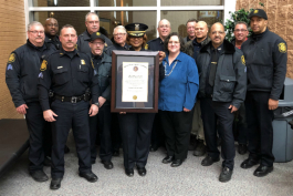 Mott Community College's Public Safety officers pose withTheresa Stephens-Lock with their accreditation award.