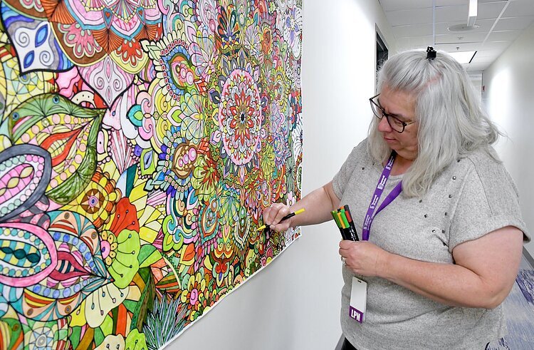 Kim Hargis, LPN works on a mandala mural at Summit Pointe. Self-expression through mandalas fosters self-reflection, focused attention, and emotional well-being.