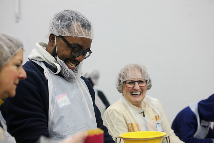 10.	Lenwood Hayman jokes along with fellow volunteer Jana Blagg who works at the Grand Blanc West Middle School pantry. 