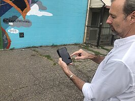 Matthew Walker, CEO of the PixelStix platform, pulls up a mural play in Carriage Town.