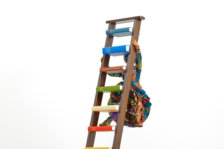 Yinka Shonibare CBE, “Magic Ladder Kid VI,” detail, 2018, Fiberglass mannequin, Dutch wax printed cotton textile, wooden ladder, hardback books, globe, buckram cloth and steel baseplate, 113.18” x 58.26” x 31.49”.  © Copyright Yinka Shonibare CBE, 20