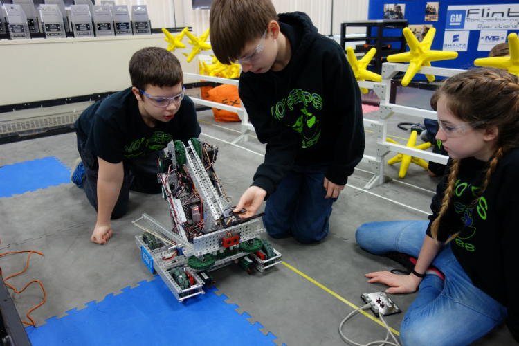 Alex Wickham, 13, works with teammates on the Carman-Ainsworth Middle School robot.