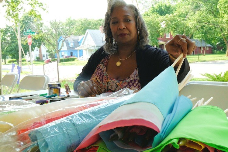 Sandra Branch, vice president of the Flint Public Art Project, readies the flags for their decoration at the Civic Park Art Parade, Thursday, July 26.