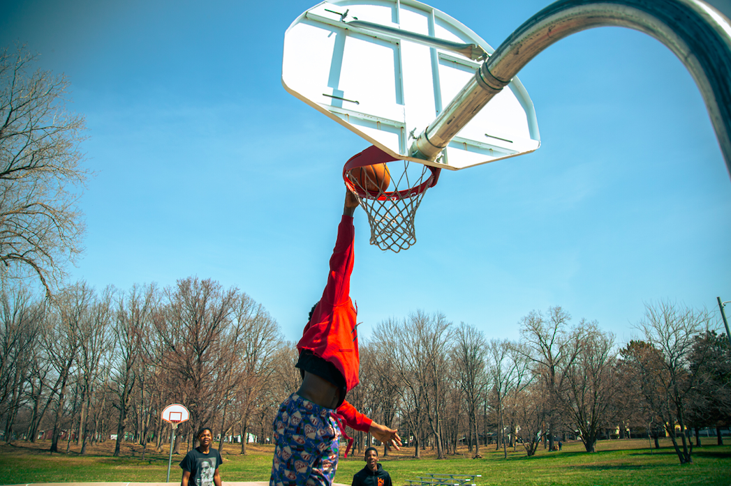 Teenagers playing a game of basketball at Sarvis Park.