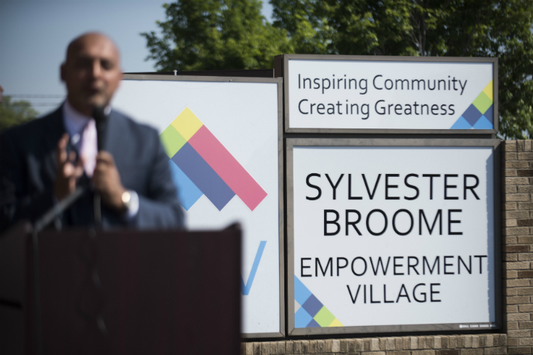 Dr. Jawad Shah, center, gives a speech during the ribbon cutting at the Sylvester Broome Empowerment Village Friday, June 29, 2018 in Flint. 
