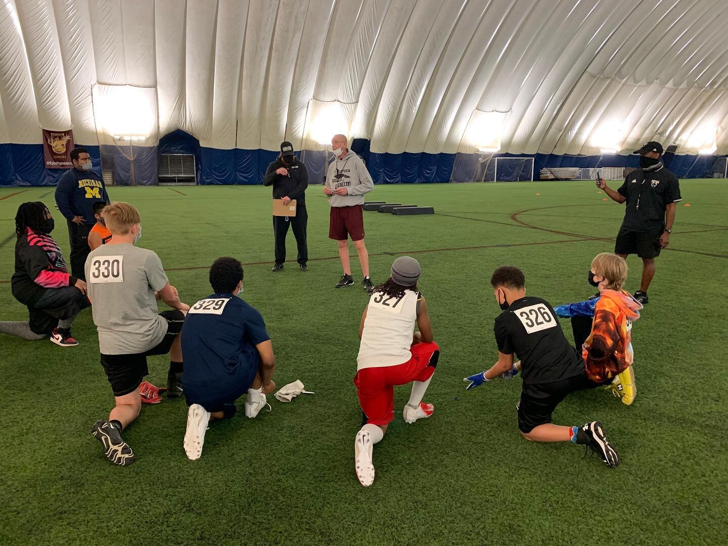 Players from a Sylvester Broome Empowerment Village football club receive instructions from a coach.