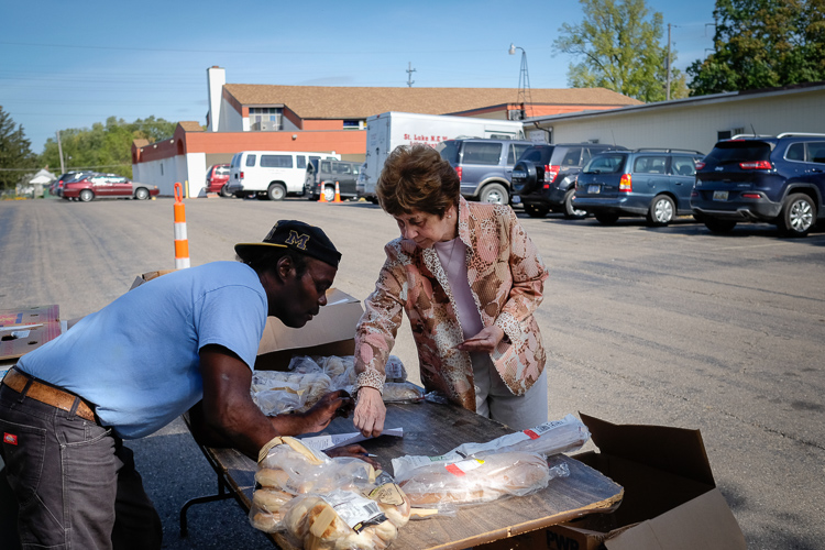 Sister Carol Weber, co-founder of St. Luke N.E.W. Life Center on the northside of Flint speaks with an employee outside the facility.