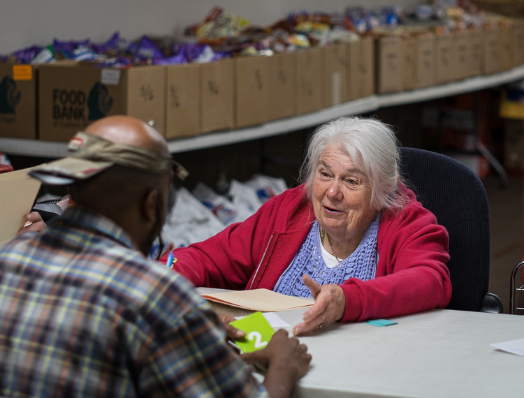 Gaytra Molinari of Millington speaks with a patron at the intake screening station at St. Luke's. Molinari always takes the time to get to know people, to listen to their concerns, and to share her faith. "This center cares about people," says Molina