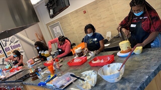 Participants in a cake decorating class by Little Suga's at the Flint Farmers Market.