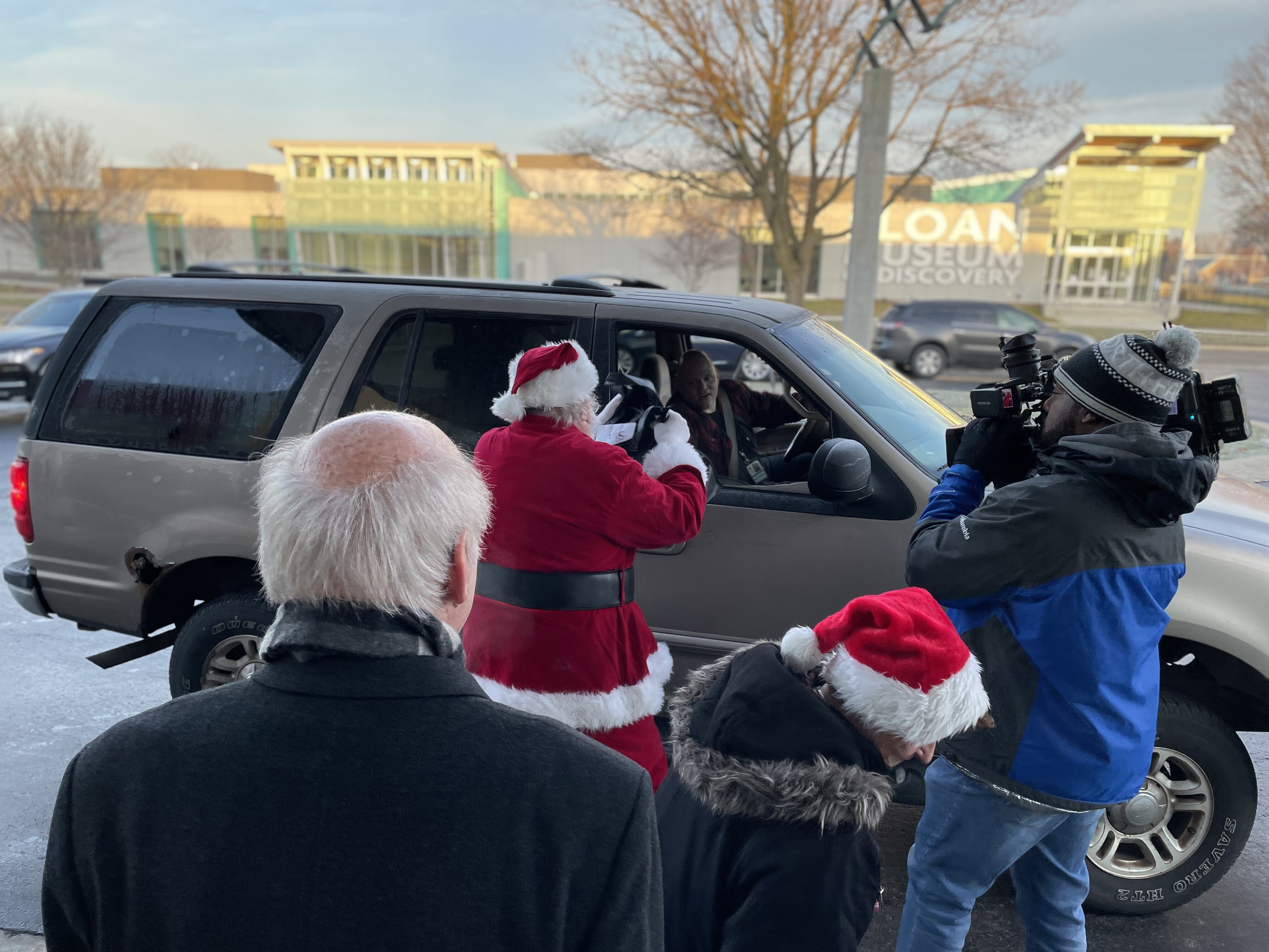 Santa and volunteers hand out gifts to FCS principals in front of the Flint Institute of Arts.