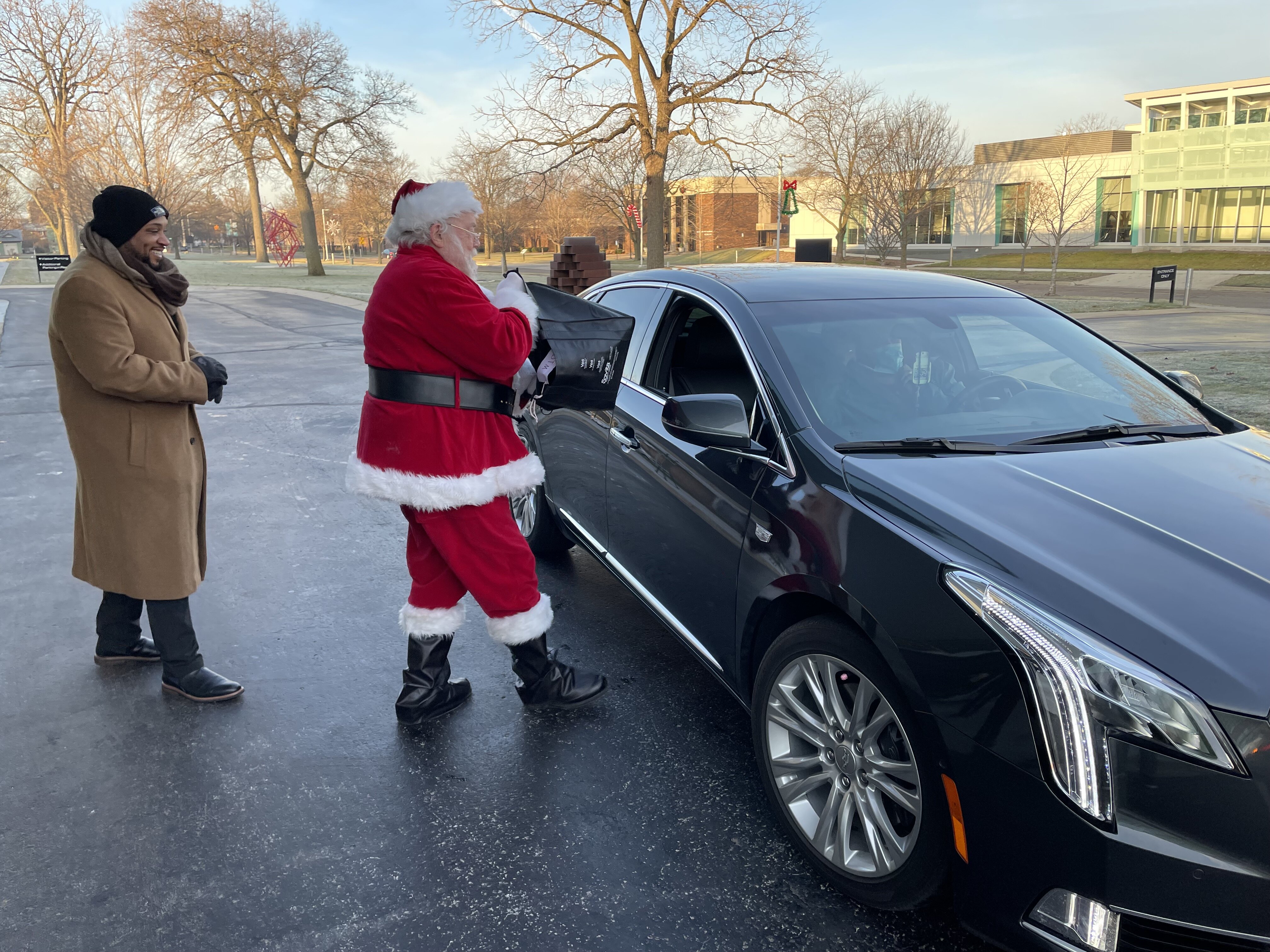 Santa and volunteers hand out gifts to FCS principals in front of the Flint Institute of Arts.