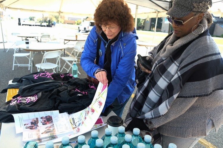 Festival-goer Torri Cross of Davison grabs a mural map during the Free City Mural Festival.