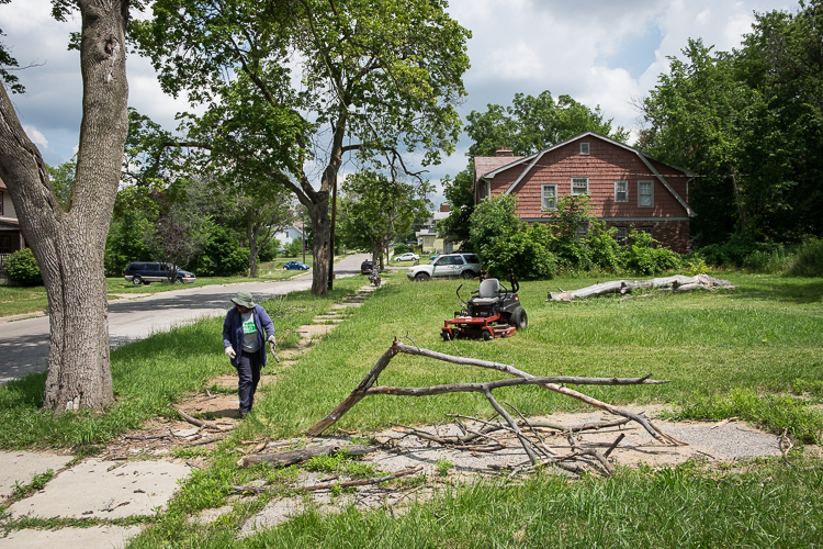 Jean Harrison of Flint looks for debris that could damage the tool shed's zero degree turn mower.