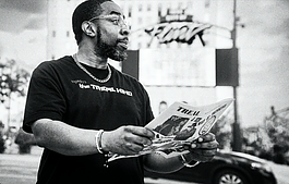 Flint native Jamal Jones reads a copy of the first issue of TREAL Magazine, a news publication he established in 1999. 