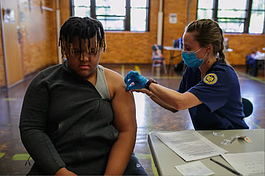 A Flint resident receives a vaccine at the Berston Field House mobile vaccine clinic held by the Genesee County Health Department in partnership with University of Michigan - Flint's Nursing program.
