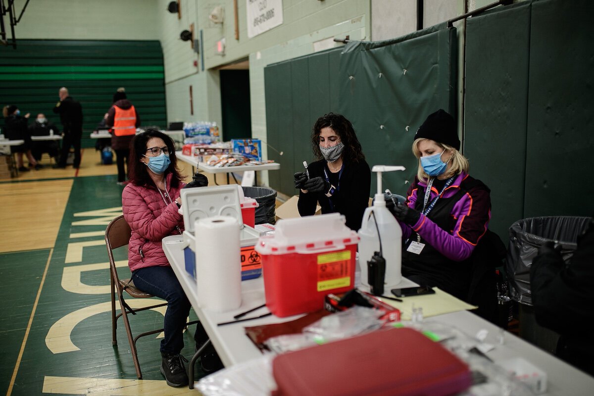 Genesee County Health Department nurses prepare the vaccines inside Flint Northwestern gymnasium.