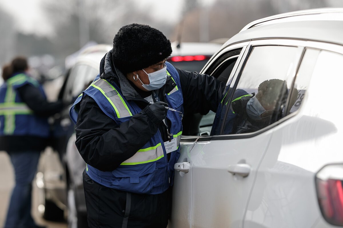 A health department nurse administers a vaccine to a patient during the drive through vaccine clinic at Northwestern.