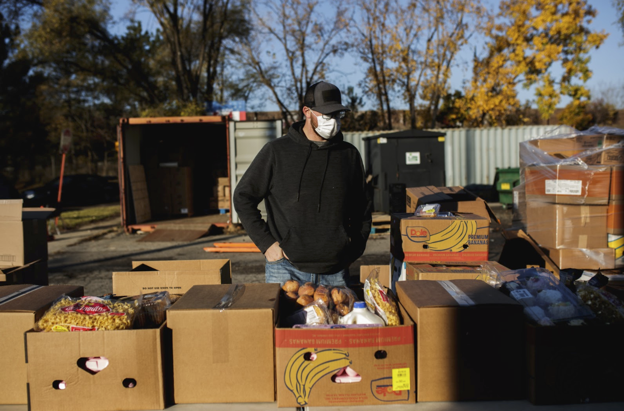 Chris Ridley, chair of UAW Local 598, helps put together food boxes on the outdoor assembly line for food distribution at the Martus Luna Pantry.