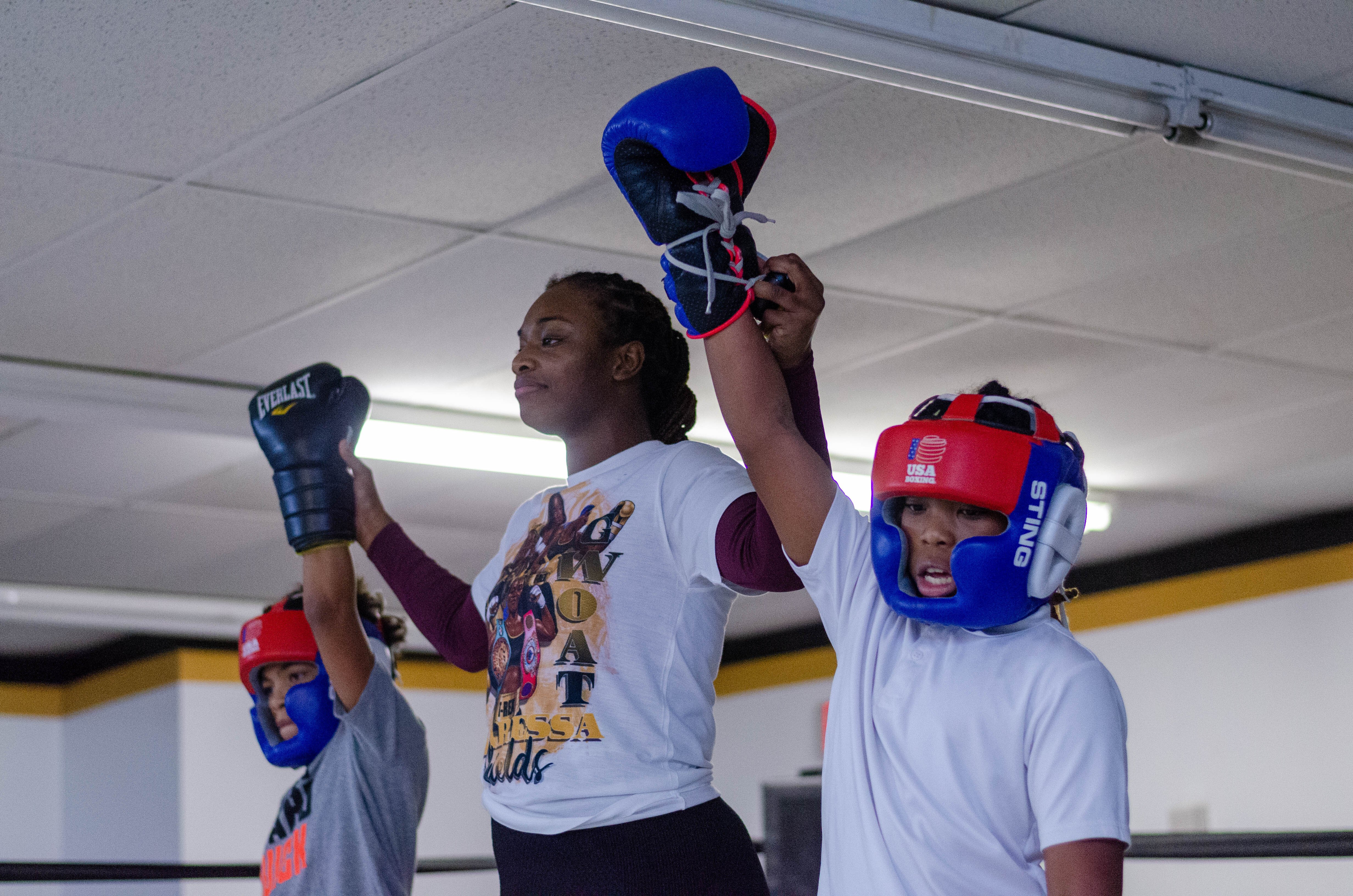 Flint native Claressa Shields holds up the gloves of two young participants during her free boxing class held on Monday, Jan. 9, 2023. 