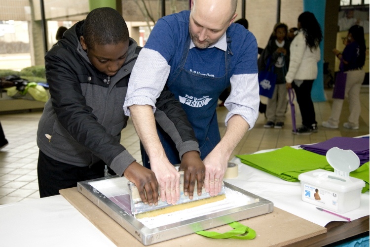 A middle school student gets a hands-on education about screen printing through YouthQuest, an after-school and summer program that recently won a $100,000 competitive grant.